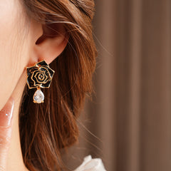Gold-tone rose stud earrings with ivory and black enamel petals plus teardrop zircon dangles — Gilded Rose Teardrop Studs.