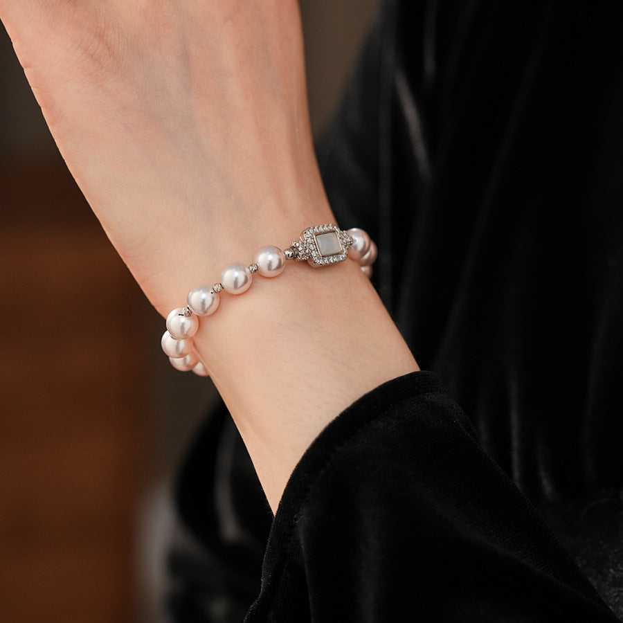 Deco Halo Pearl Bracelet featuring luminous pearls and a pavé-framed rectangular mother-of-pearl charm.