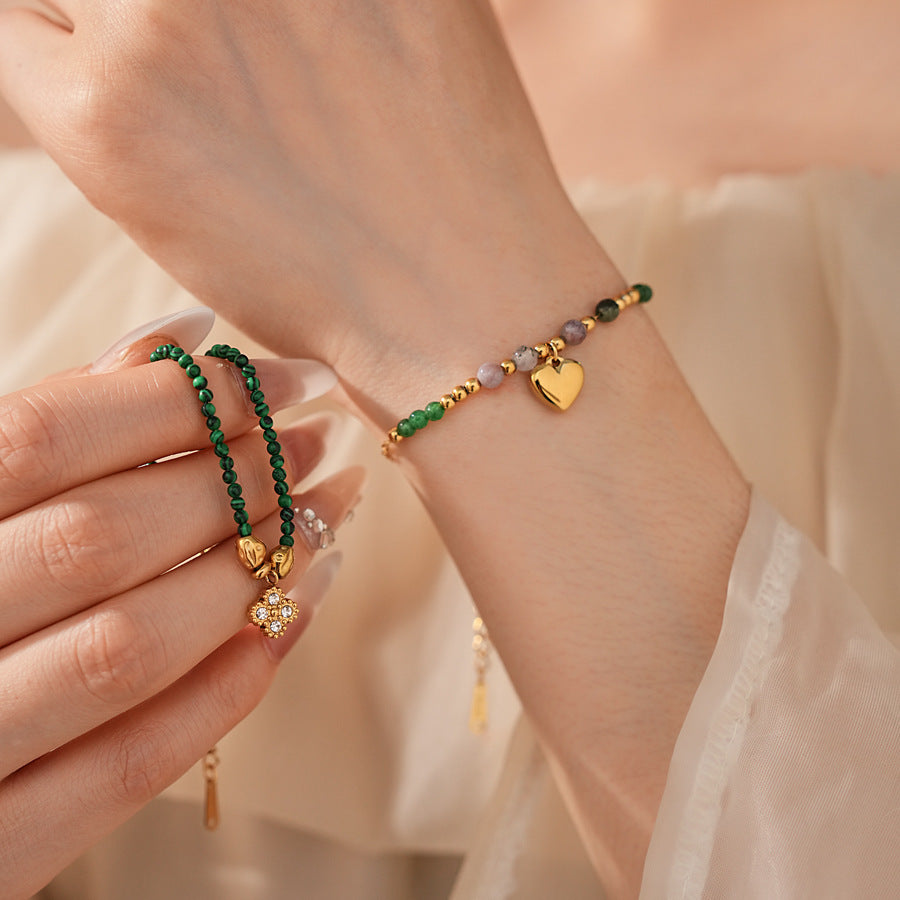 Two variant options of a malachite charm bracelet: beaded green strand with a crystal bloom charm, and a gold-tone chain with malachite accents and a heart pendant — Malachite Charm Bracelet (Variants).