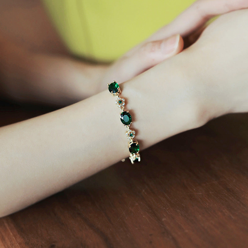 Gold-plated bracelet with emerald crystal centerpiece and zircon accents