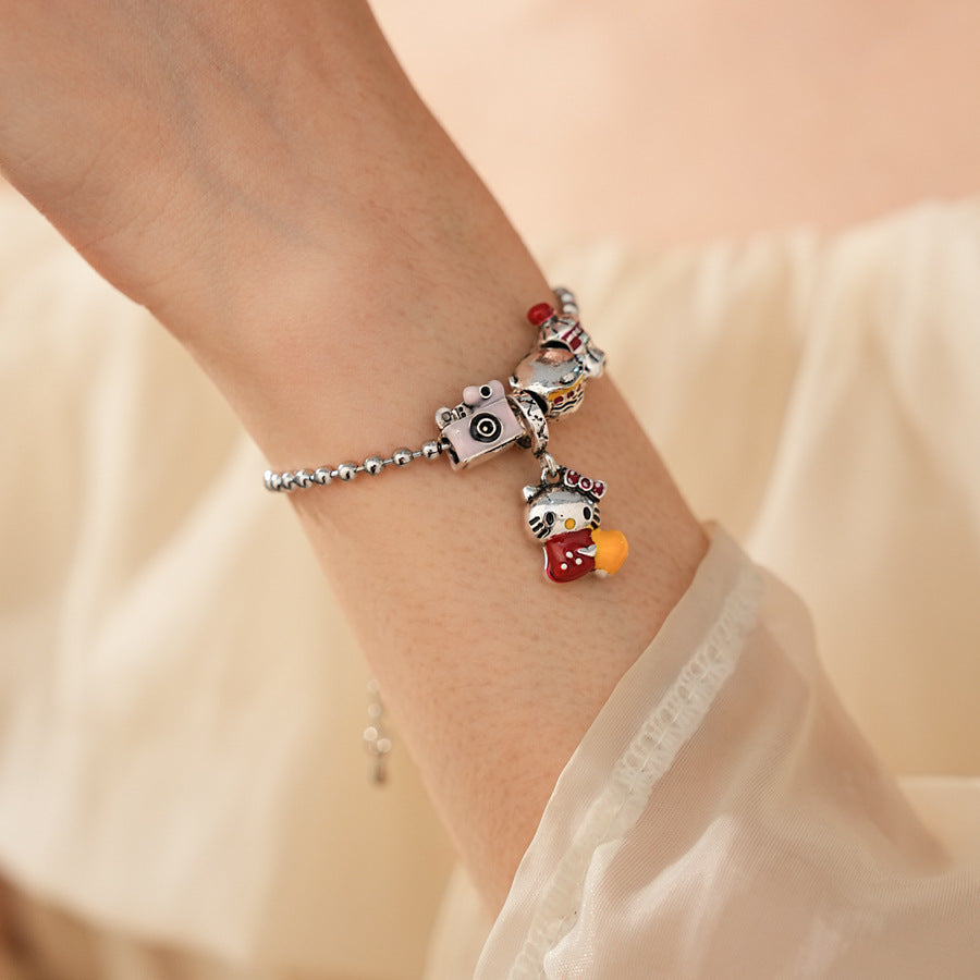 Kawaii Charm Story Bracelet with cartoon cat, burger, camera, and bell charms on silver-tone bead chain
