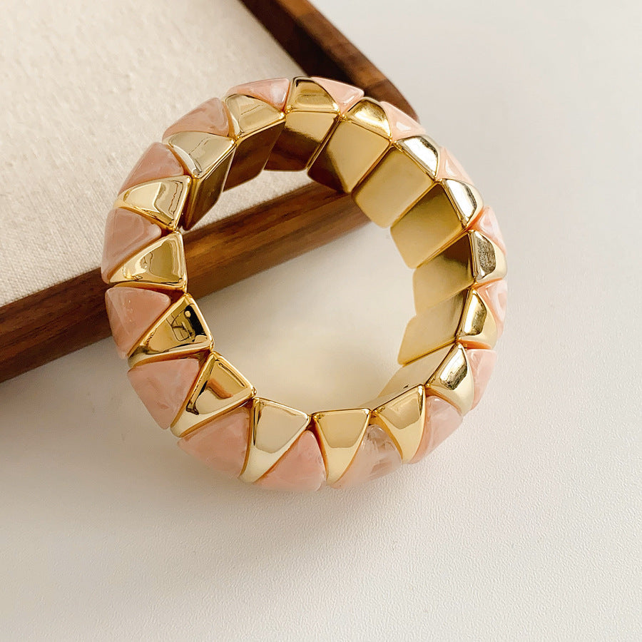 Gold-tone segmented bangle with marbled acrylic dome tiles — Gilded Capsule Resin Bangle.