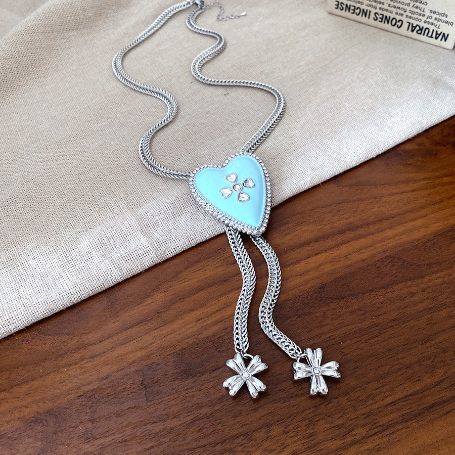 Lariat necklace with beaded-edge heart pendant and twin tassel blossoms on model — Regal Heart Tassel Lariat Necklace.