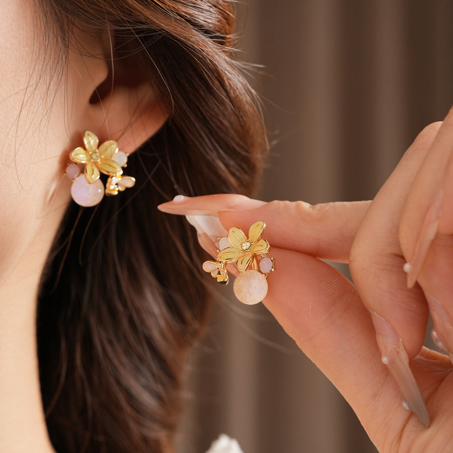 Honeybee Blossom Crystal Stud Earrings — gold flower studs with tiny bee charm and pink crystal orb on black jewelry box