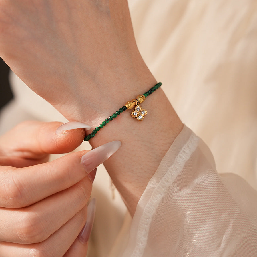Two variant options of a malachite charm bracelet: beaded green strand with a crystal bloom charm, and a gold-tone chain with malachite accents and a heart pendant — Malachite Charm Bracelet (Variants).