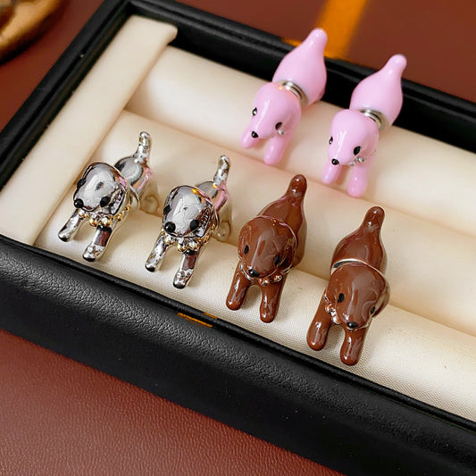 Glossy 3D puppy stud earrings in silver, pink, and coffee on post backs — Playful Pup Stud Earrings.