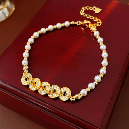 Gold link and pearl chain bracelet with zircon accents on green velvet background – Celestial Pearl Chain Bracelet by Glazenya