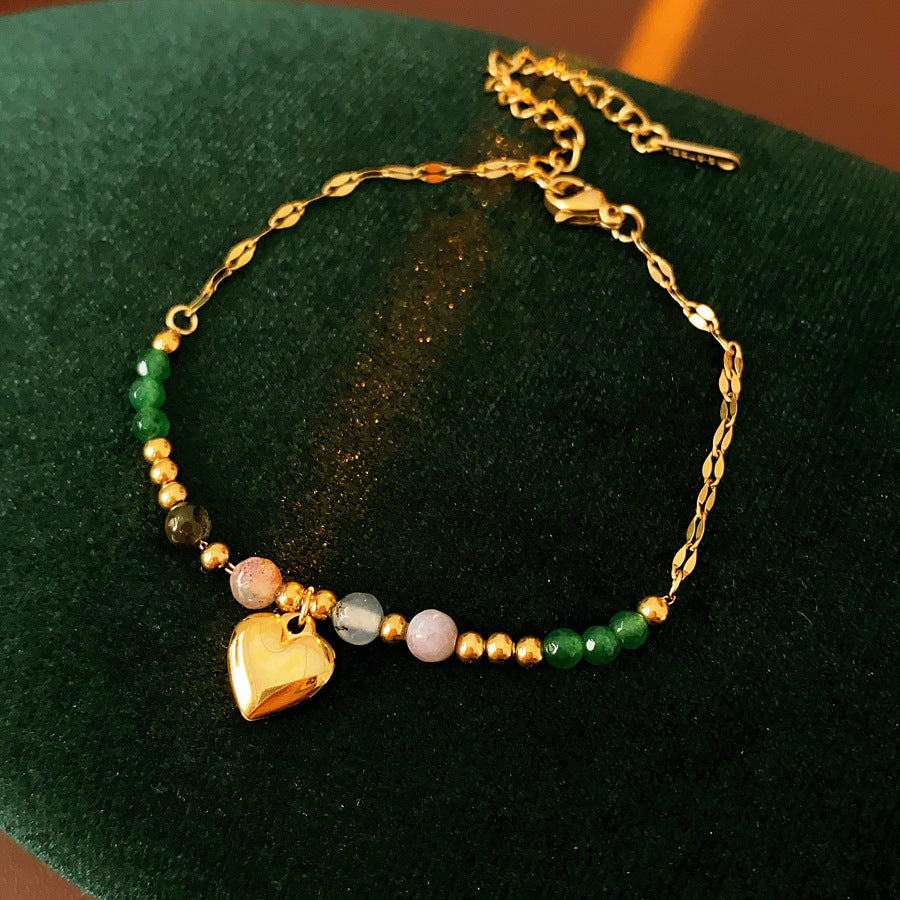 Two variant options of a malachite charm bracelet: beaded green strand with a crystal bloom charm, and a gold-tone chain with malachite accents and a heart pendant — Malachite Charm Bracelet (Variants).
