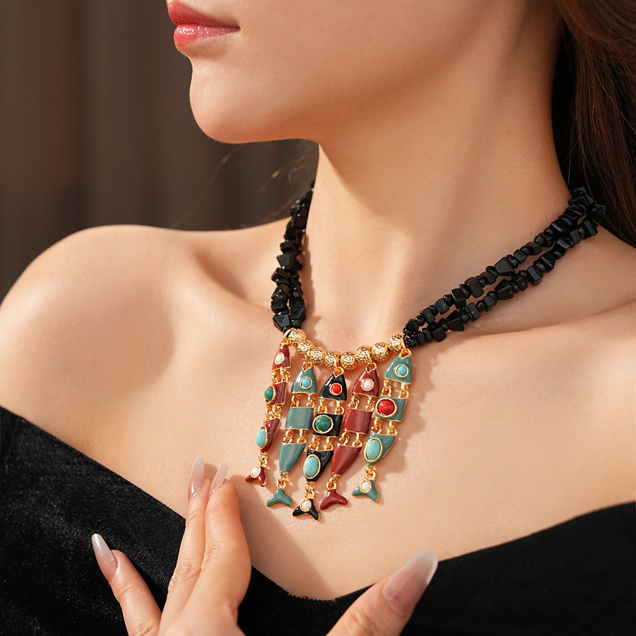Statement necklace with articulated fishbone fringe, gold beads, and red or black chip strands — Kaleido Fishbone Fringe Necklace.