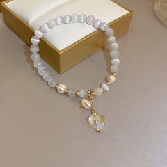 Gold-plated bracelet collection with pearls, cat’s eye stones, and floral motifs