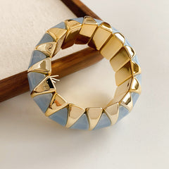 Gold-tone segmented bangle with marbled acrylic dome tiles — Gilded Capsule Resin Bangle.