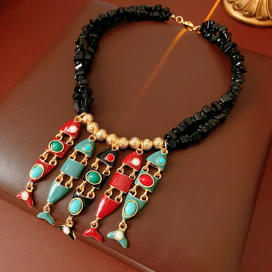 Statement necklace with articulated fishbone fringe, gold beads, and red or black chip strands — Kaleido Fishbone Fringe Necklace.