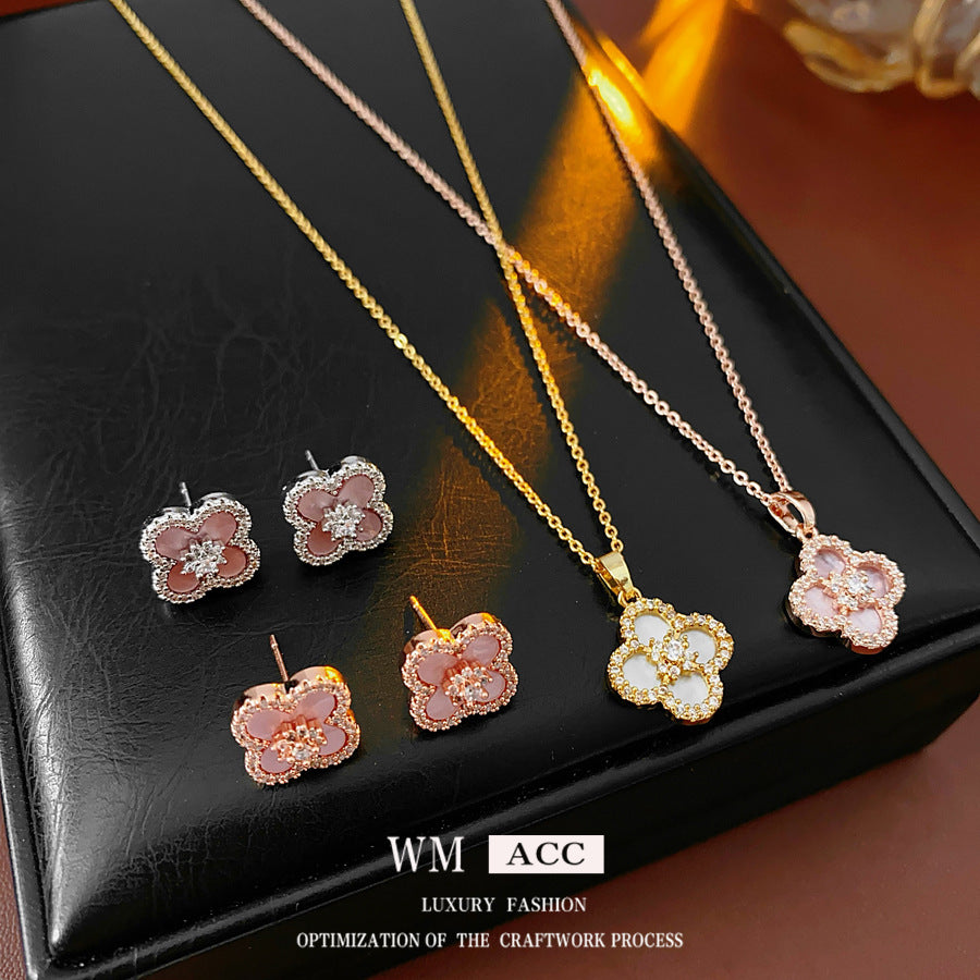 Clover jewelry collection — earrings and necklace displayed together