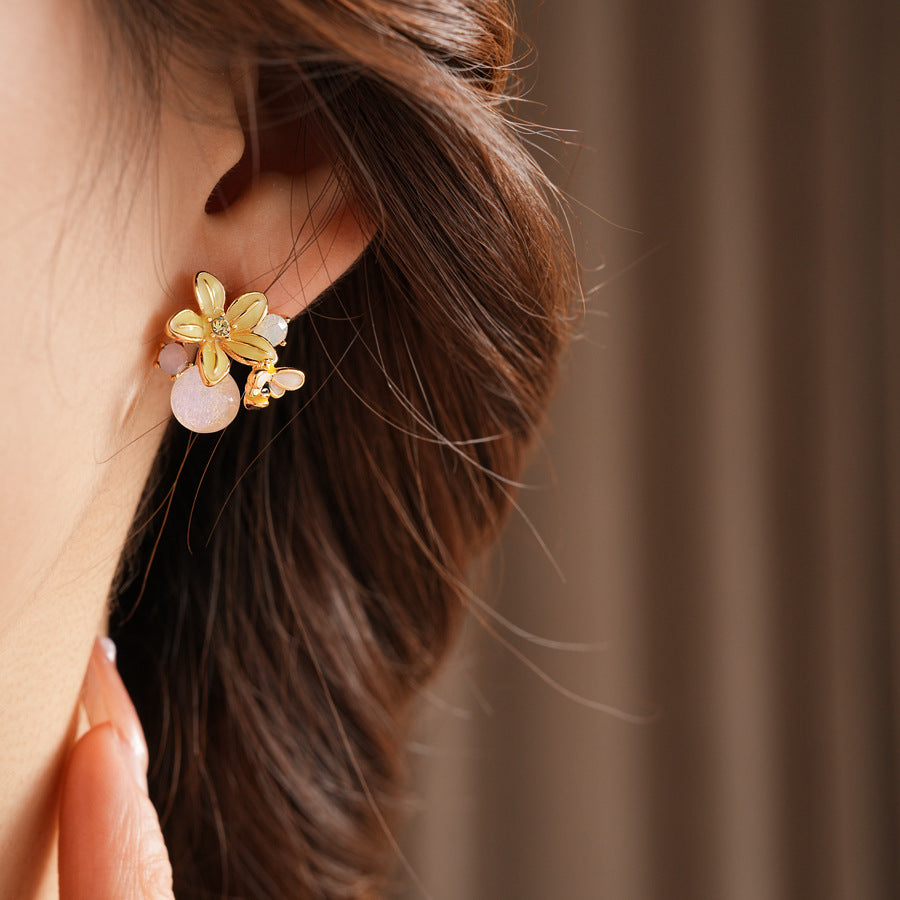 Honeybee Blossom Crystal Stud Earrings — gold flower studs with tiny bee charm and pink crystal orb on black jewelry box