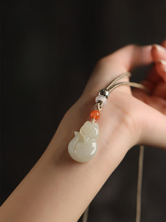 Hand-carved Hetian jade fox pendant on braided cord — Peach Blossom Hetian Jade Fox Pendant