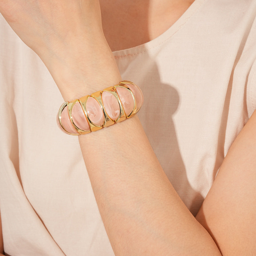 Gold-tone segmented bangle with marbled acrylic dome tiles — Gilded Capsule Resin Bangle.