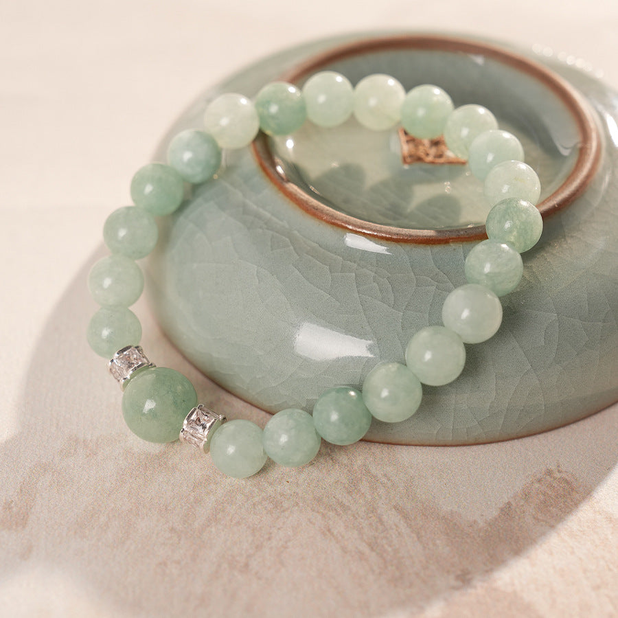 A fresh light green round bead bracelet with two silver zircon spacer beads and a large main bead - Celadon Serenity Bracelet.