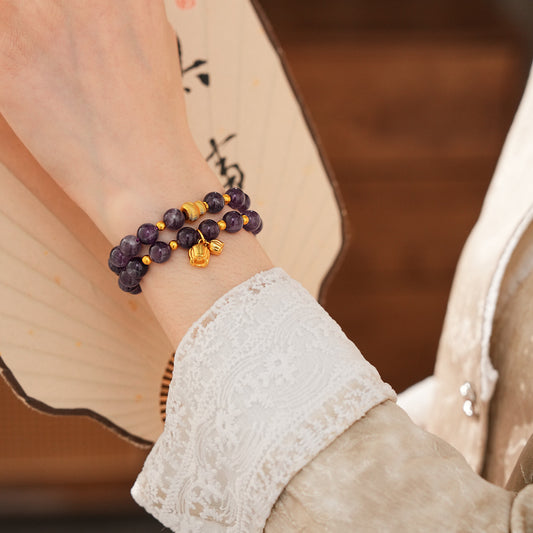 Natural amethyst beaded bangle with gold-tone accents and a lucky charm (Floral or Gourd) — Violet Fortune Amethyst Bangle.