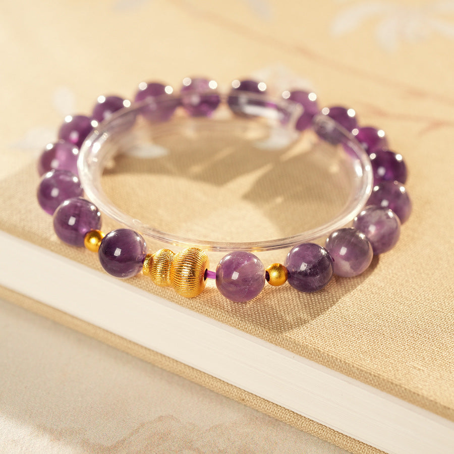 Natural amethyst beaded bangle with gold-tone accents and a lucky charm (Floral or Gourd) — Violet Fortune Amethyst Bangle.