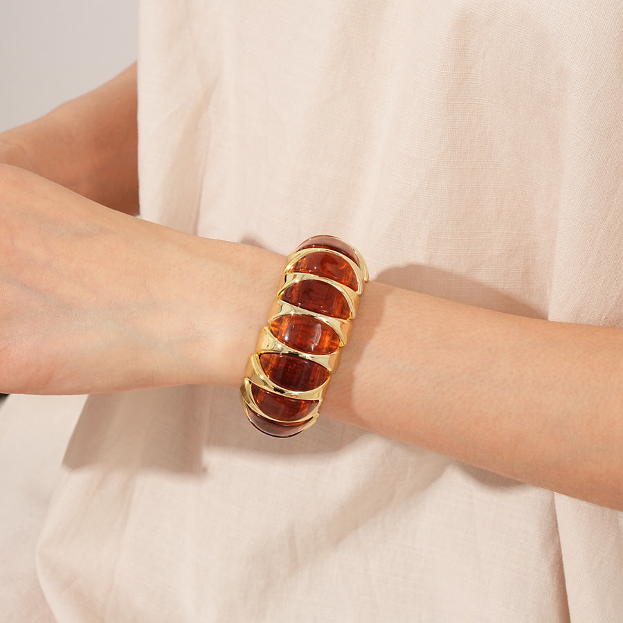 Gold-tone segmented bangle with marbled acrylic dome tiles — Gilded Capsule Resin Bangle.