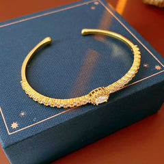Elegant open bangle in gold with sparkling zircon stones and a marquise centerpiece, light-luxury adjustable bracelet.