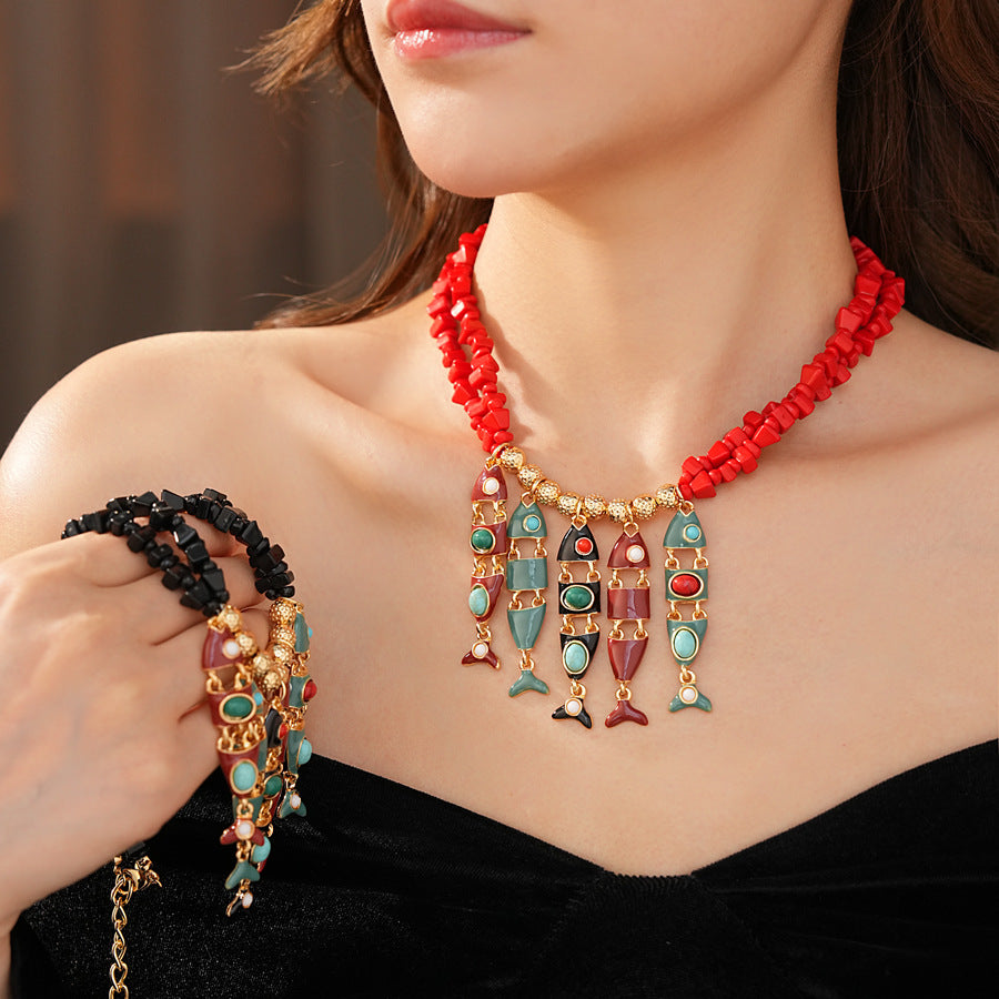 Statement necklace with articulated fishbone fringe, gold beads, and red or black chip strands — Kaleido Fishbone Fringe Necklace.