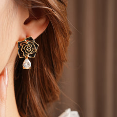 Gold-tone rose stud earrings with ivory and black enamel petals plus teardrop zircon dangles — Gilded Rose Teardrop Studs.