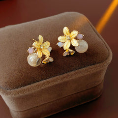 Honeybee Blossom Crystal Stud Earrings — gold flower studs with tiny bee charm and pink crystal orb on black jewelry box