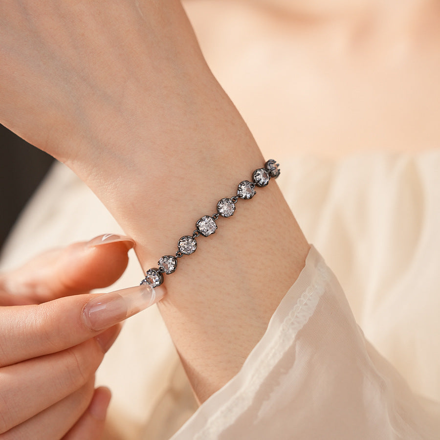 Midnight Sparkle Bracelet with round and pear-cut zircons set in noir metal, adjustable chain