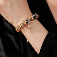 Leopard Cross Luxe Bracelet with leopard-patterned beads, zircon accents, black 8-ball bead, and cross pendant on gold chain