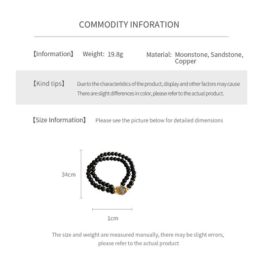 Black sandstone double-wrap bracelet with gray moonstone focal and gold accents — Midnight Moonstone Wrap Bracelet.