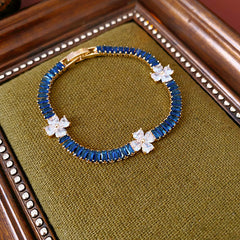 Petal Sparkle Tennis Bracelet lineup in gold and silver with pink and blue accents – baguette zircon floral design