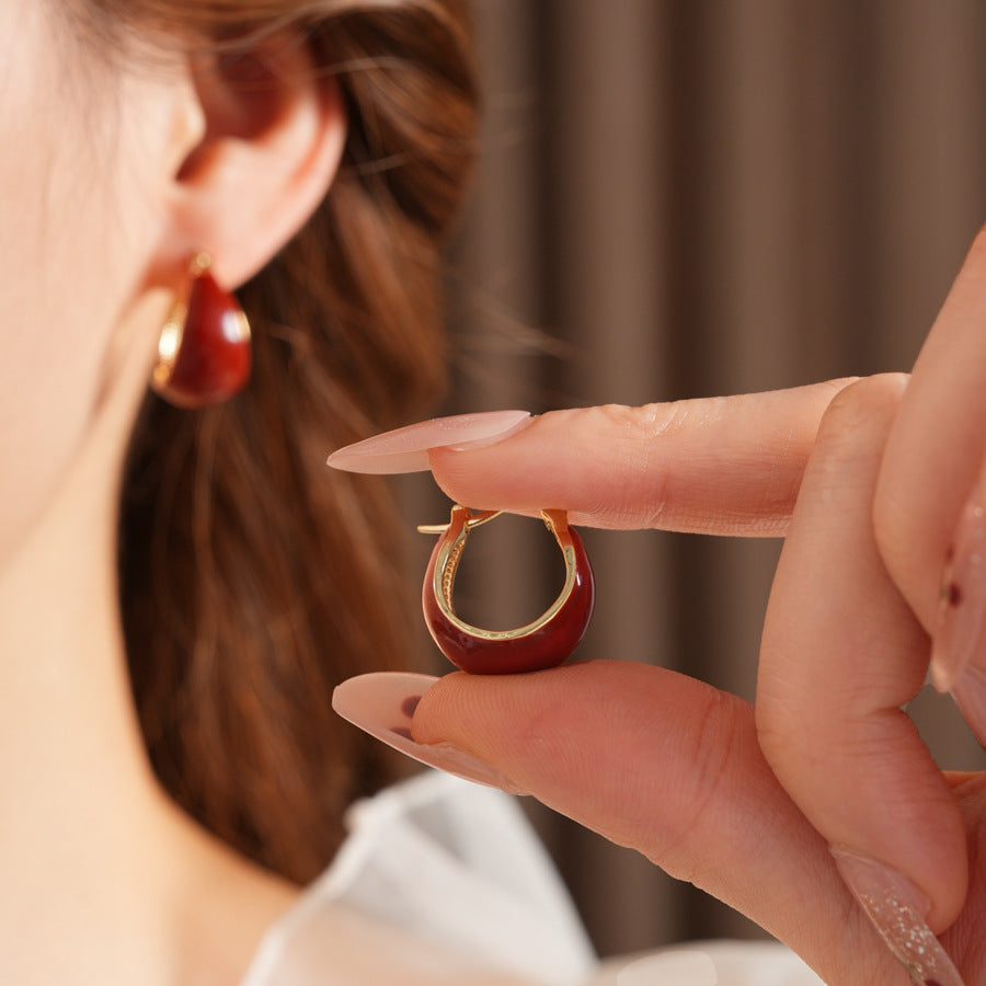 Cherry-red enamel dome huggie hoop earrings with gold tone finish — Cherry Lacquer Dome Huggies.