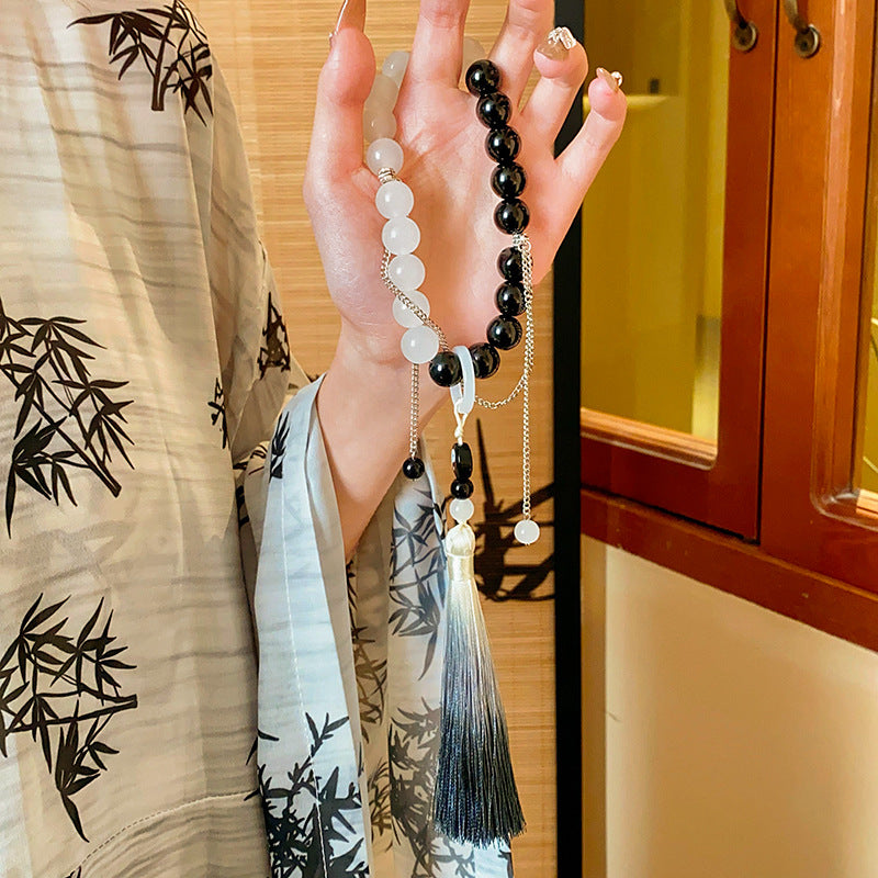Black and white colored-glass beaded bracelet with yin-yang charm and gradient tassel — Yin-Yang Serenity Tassel Bracelet by Glazenya.