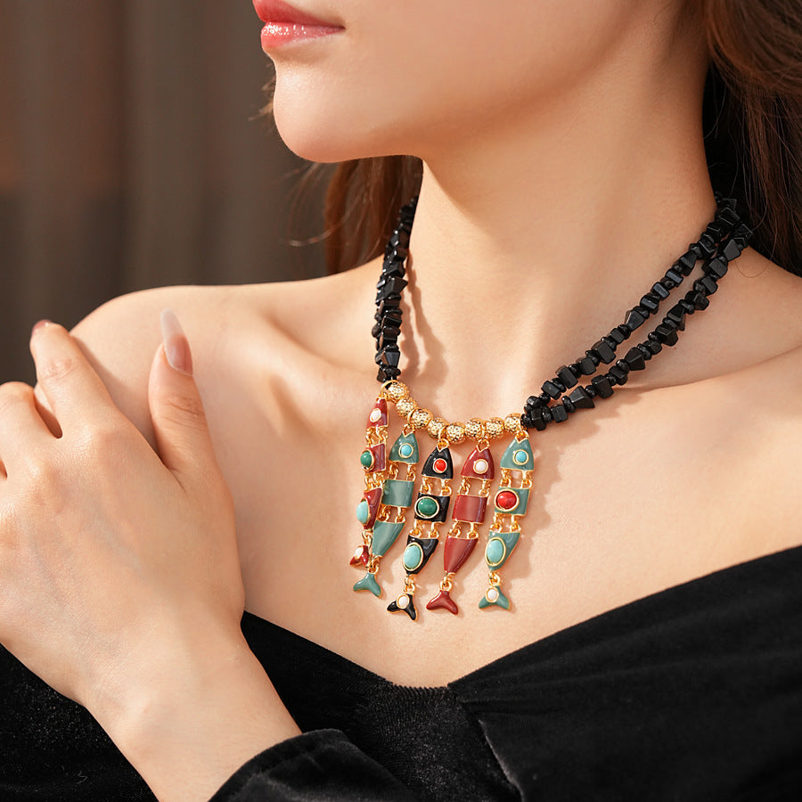 Statement necklace with articulated fishbone fringe, gold beads, and red or black chip strands — Kaleido Fishbone Fringe Necklace.