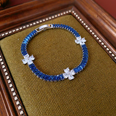 Petal Sparkle Tennis Bracelet lineup in gold and silver with pink and blue accents – baguette zircon floral design