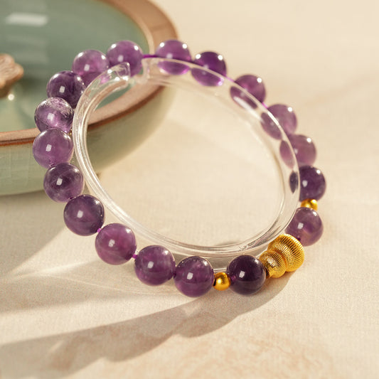 Natural amethyst beaded bangle with gold-tone accents and a lucky charm (Floral or Gourd) — Violet Fortune Amethyst Bangle.