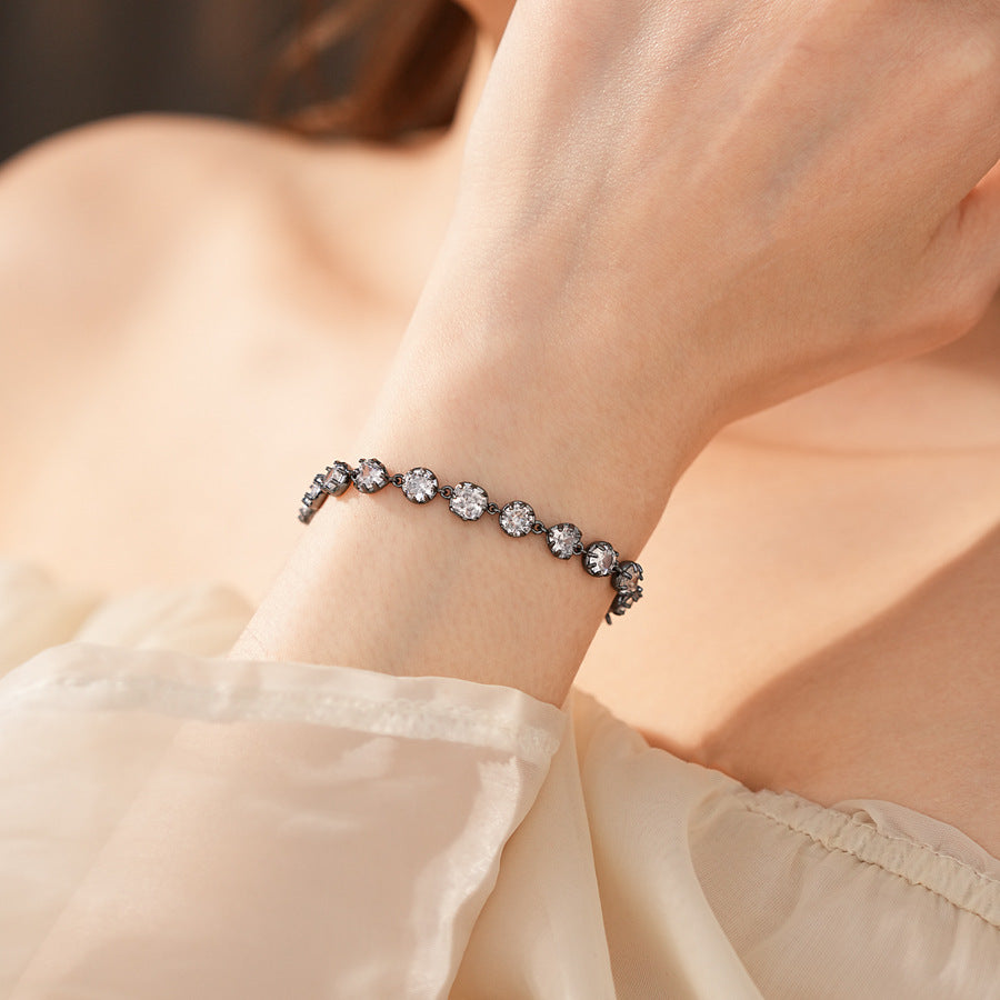 Midnight Sparkle Bracelet with round and pear-cut zircons set in noir metal, adjustable chain