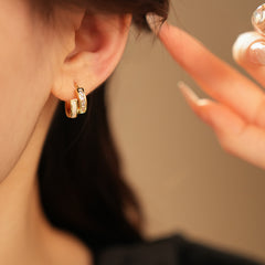 Gold huggie hoop earrings with ivory enamel arc and baguette CZ row — Luna Arc Enamel Baguette Huggies.