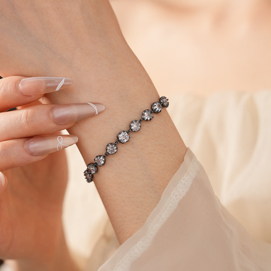 Midnight Sparkle Bracelet with round and pear-cut zircons set in noir metal, adjustable chain