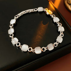 Cat’s Eye Link Bracelet in two color variants (rose gold and silver) displayed on a jewelry box.