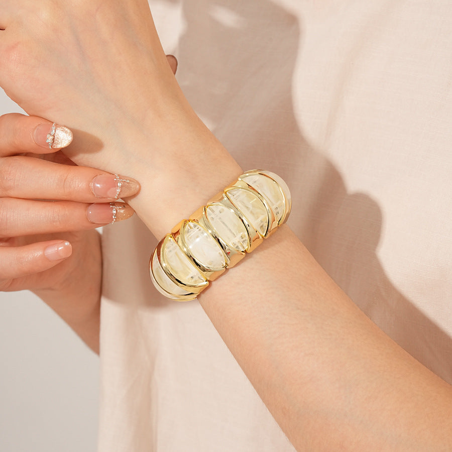 Gold-tone segmented bangle with marbled acrylic dome tiles — Gilded Capsule Resin Bangle.