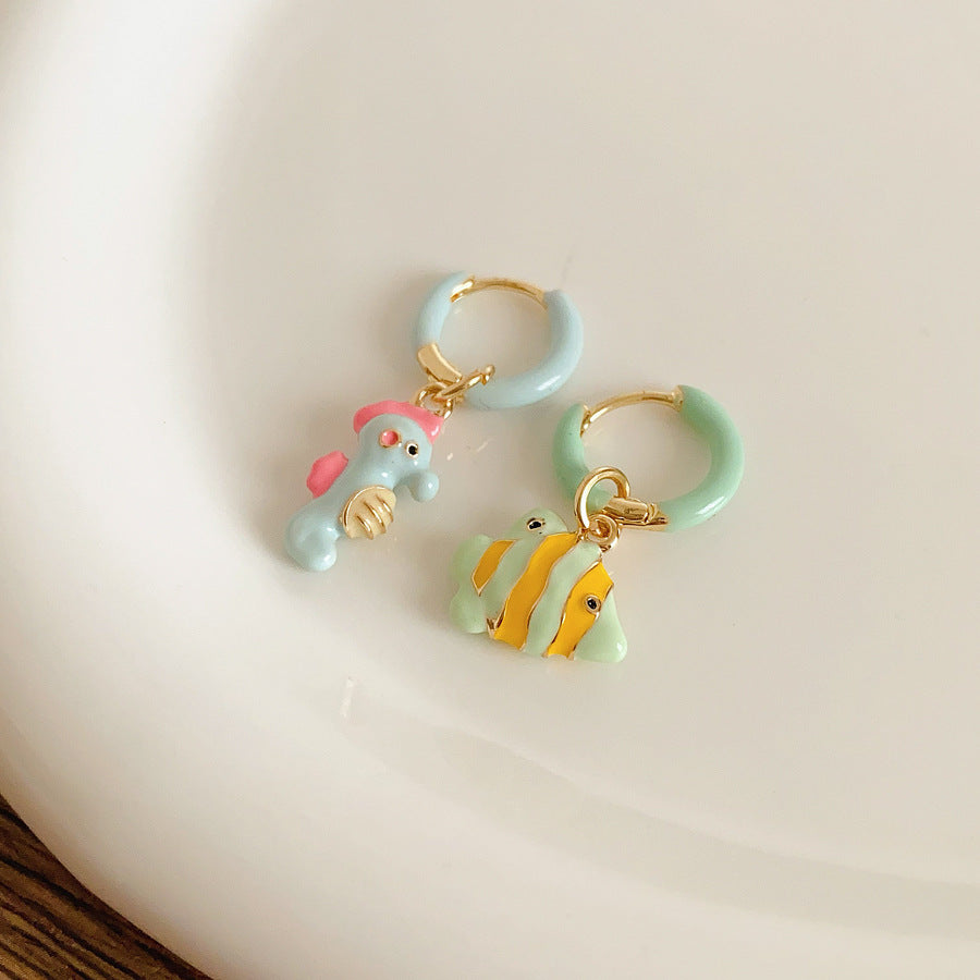 Pastel enamel huggie earrings with mismatched seahorse and striped fish charms — Seafoam Mismatch Ocean Charm Huggies.
