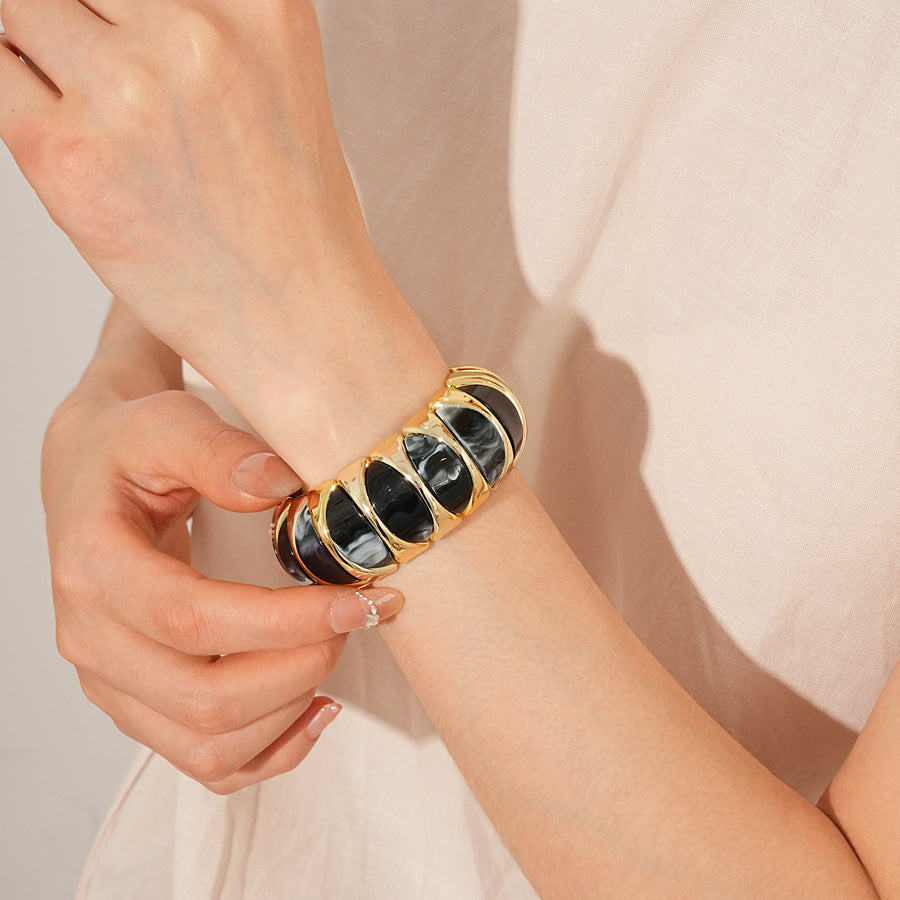 Gold-tone segmented bangle with marbled acrylic dome tiles — Gilded Capsule Resin Bangle.
