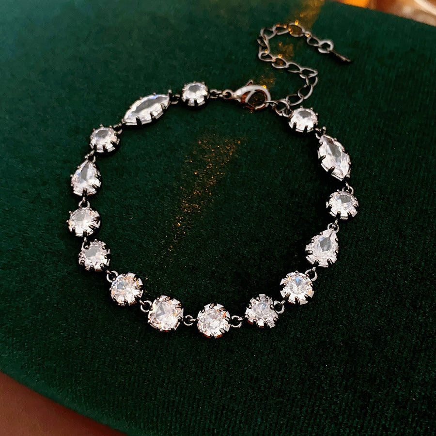 Midnight Sparkle Bracelet with round and pear-cut zircons set in noir metal, adjustable chain