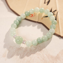 A fresh light green round bead bracelet with two silver zircon spacer beads and a large main bead - Celadon Serenity Bracelet.