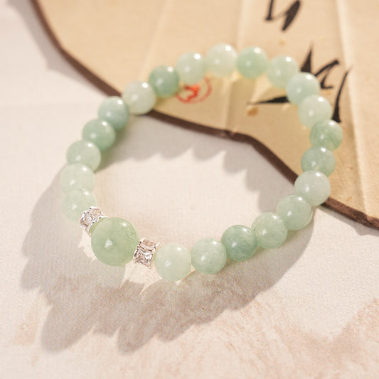 A fresh light green round bead bracelet with two silver zircon spacer beads and a large main bead - Celadon Serenity Bracelet.