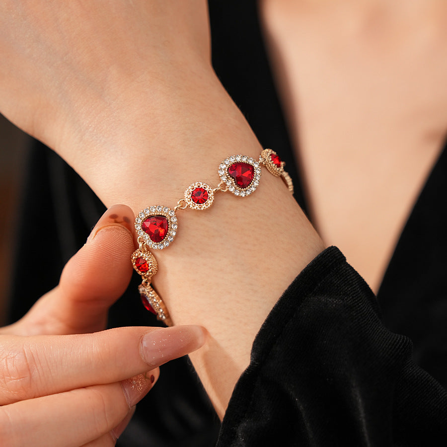 Crimson Heart Luxe Collection with red heart gemstone necklace, bracelet, and earrings, accented with pavé details