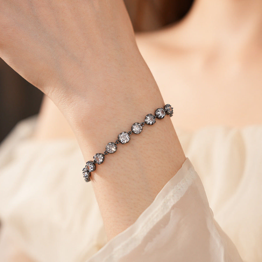 Midnight Sparkle Bracelet with round and pear-cut zircons set in noir metal, adjustable chain