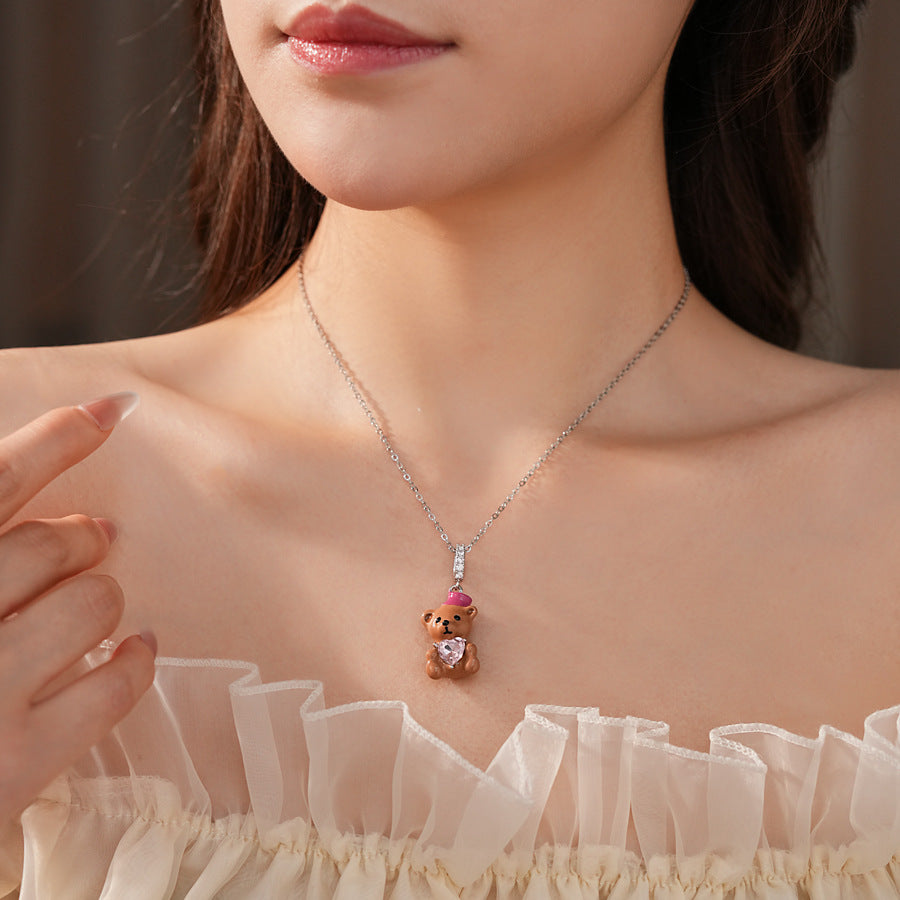 Silver-tone necklace with coffee teddy pendant and pink hat, matching teddy stud earrings with heart crystal — Sweetheart Teddy Crystal Jewelry.